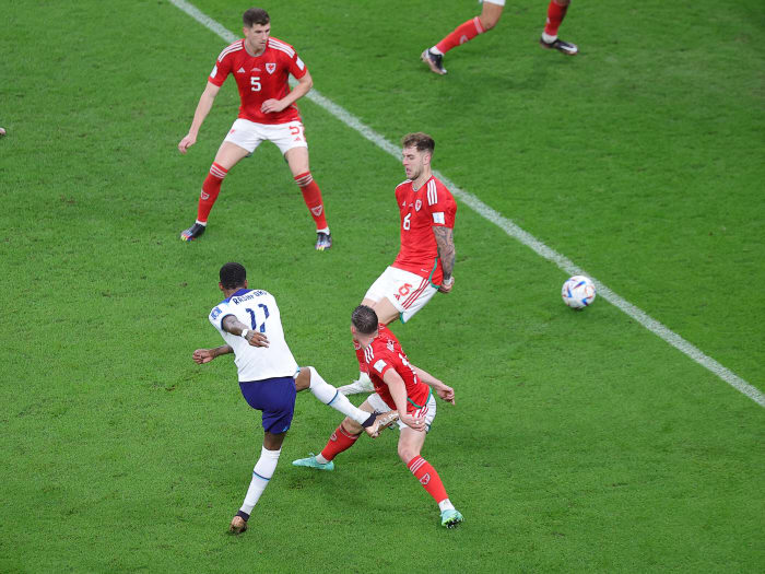 Marcus Rashford pictured (bottom left) shooting to score England's third goal in a 3-0 win over Wales at the 2022 FIFA World Cup in Qatar